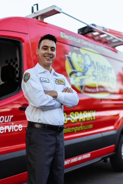 Mister Sparky electrician Benito standing in front of branded red service van in Southern Minnesota Time To Schedule Heater Maintenance